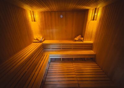A cozy wooden sauna interior with warm lighting creating a relaxing atmosphere.
