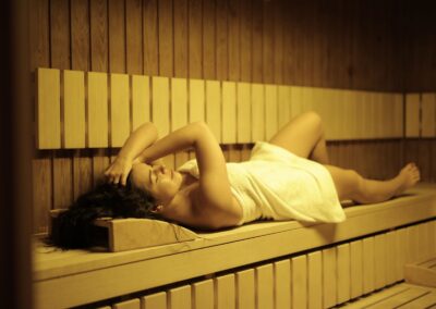 A woman relaxing in a sauna wrapped in a towel, experiencing ultimate wellness and comfort.